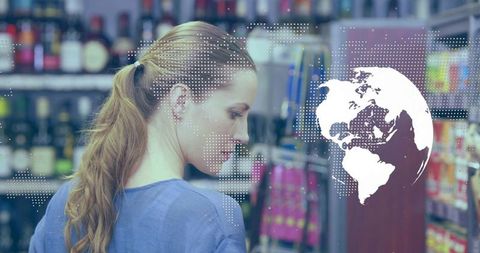 Mid-adult woman scanning beverage shelf with digital globe overlay for retail analytics