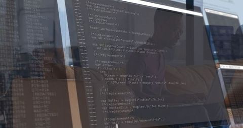 Male software developer coding in modern office with multiple screens