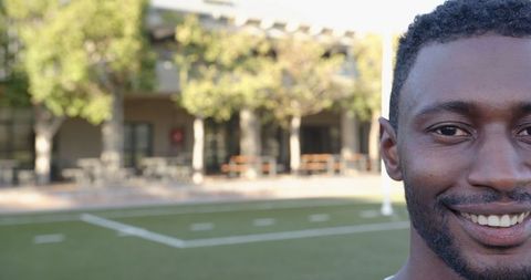 Smiling man outdoors near urban athletic field