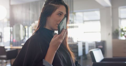 Woman Communicating on Smartphone in Hair Salon