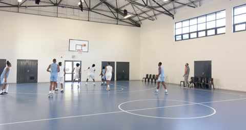 Basketball Team Practicing in Indoor Gym for Skill Enhancement