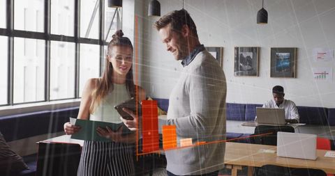 Colleagues Discussing Digital Content in Modern Office Lounge
