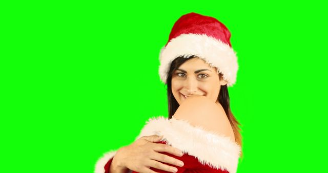 Smiling Woman in Santa Hat Celebrating Christmas Against Green Background - Download Free Stock Images Pikwizard.com