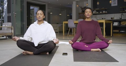 Diverse Women Meditating at Home in Modern Living Space