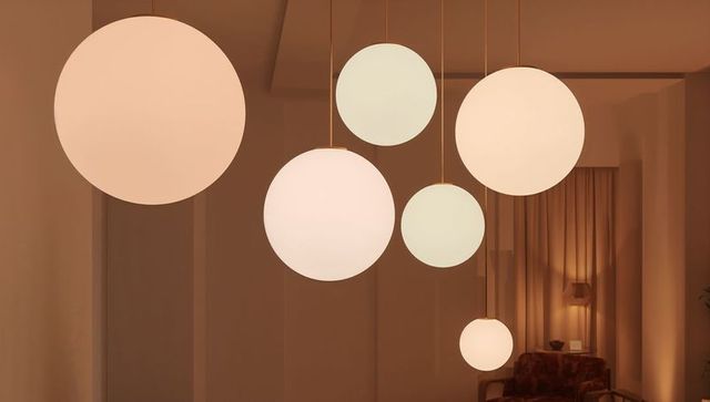Cluster of globe pendant lights casting warm ambient glow over minimalist lounge nook