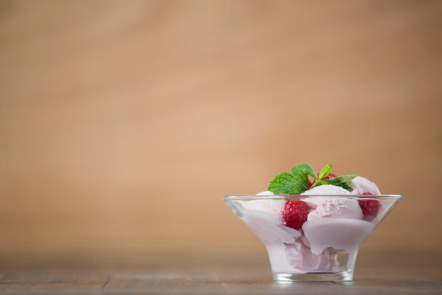 Cup of raspberry ice cream decorated with mint and raspberries