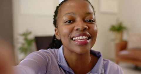 Smiling woman recording selfie vlog at home, close-up portrait for social media content