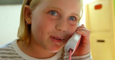 Young girl imagining executive role with toy phone