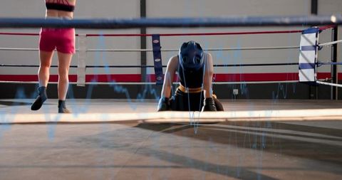 Kneeling female boxer wearing headgear and gloves in ring with blue waveform overlay