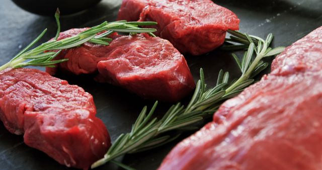 Fresh Raw Beef Steaks with Rosemary on Dark Surface - Download Free Stock Images Pikwizard.com