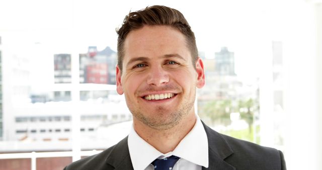 Confident Businessman Smiling in Office Environment with Cityscape Background - Download Free Stock Images Pikwizard.com