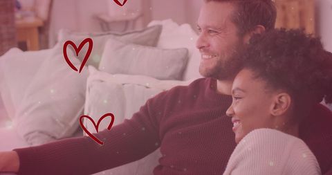 Diverse Couple Embracing on Sofa with Romantic Overlay Effects