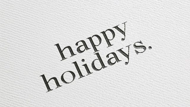 Minimal diagonal letterpress 'happy holidays.' on textured white cardstock with worn serif