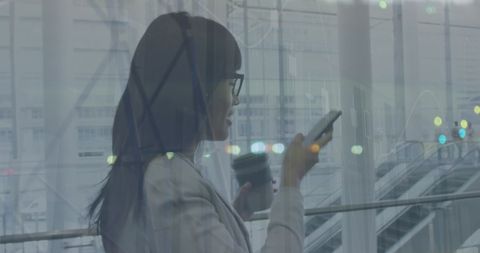 Businesswoman checking smartphone at modern office