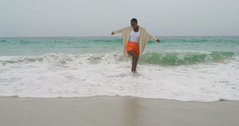 Joyful Woman Dancing in Waves at Serene Beach