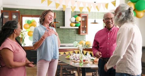 Joyful Senior Friends Gathering for Celebration in Modern Kitchen