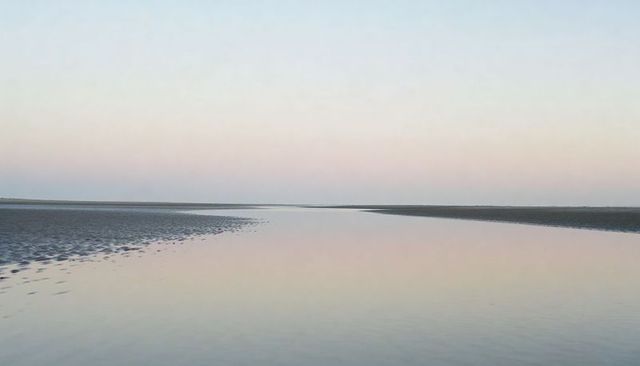 Minimalist tidal flat at dusk with central shallow channel reflecting pastel gradient sky