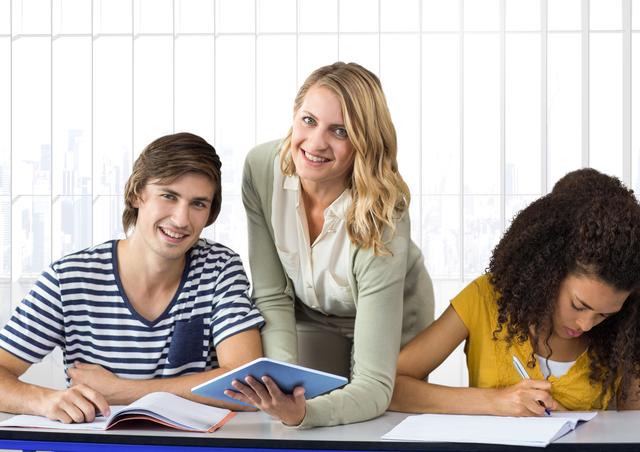Teacher assisting students in classroom setting. Male student holding tablet and smiling, female student writing in notebook. Ideal for educational content, school brochures, academic websites, and learning resources.