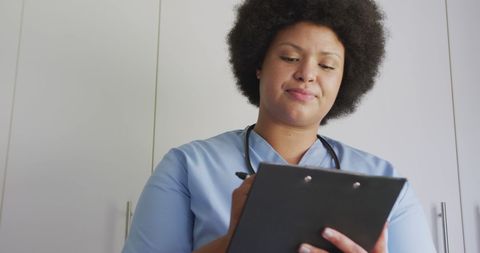 Confident African American Female Doctor Taking Notes