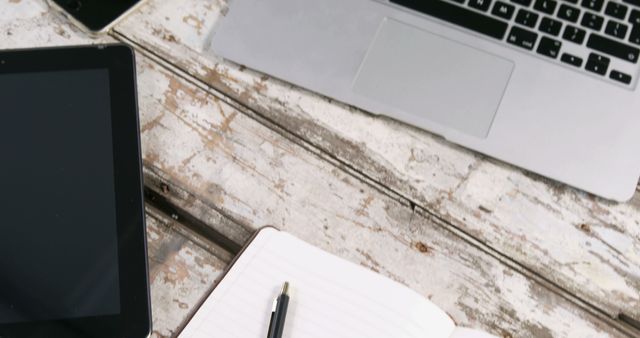 Workplace Setup with Laptop, Tablet, and Notebook on Weathered Wooden Table - Download Free Stock Images Pikwizard.com