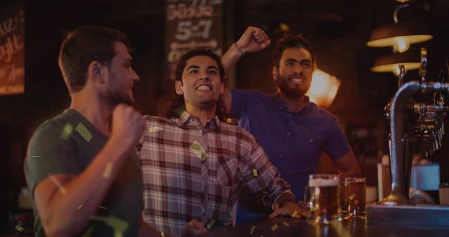 Friends are gathered at a bar, enthusiastically celebrating as they watch a sports game. Beer glasses on the counter evoke a casual and lively atmosphere. Perfect for use in promotions related to social gatherings, bars, sports events, or friendship themes.