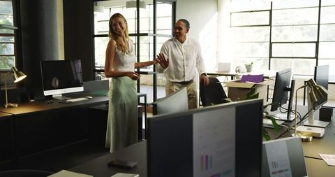 Colleagues Laughing and Collaborating in Modern Office Space