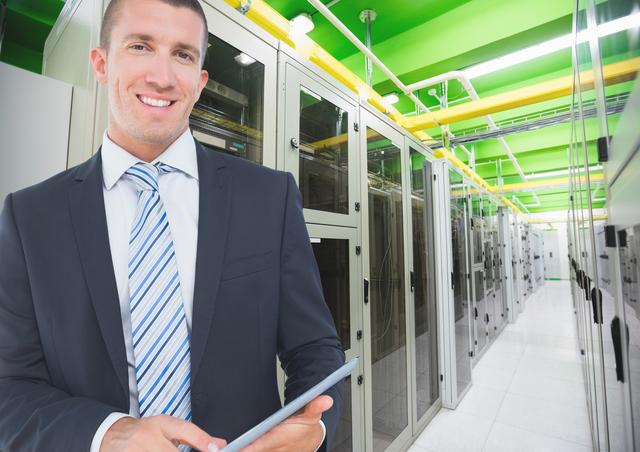 Businessman standing with digital tablet in a modern server room, surrounded by server racks and network equipment. Ideal for use in corporate brochures, IT service promotions, data security campaigns, and technology blogs showcasing concise professional environments.
