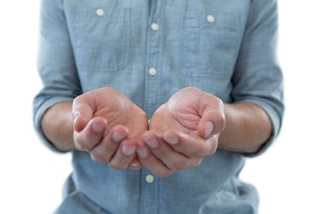 This image shows a man with cupped hands as if holding an invisible object, against a white background. The close-up focus on the hands makes it ideal for concepts related to offering, giving, receiving, or emptiness. It can be used in presentations, advertisements, or articles discussing charity, support, or abstract concepts.