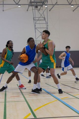 Intense basketball game on indoor court with players competing