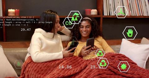 Two Women Relaxing on Couch Using Smartphones with Augmented Reality Eco Overlays