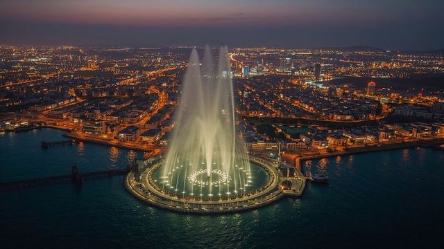 Mesmerizing nighttime illuminated fountain display on coastline