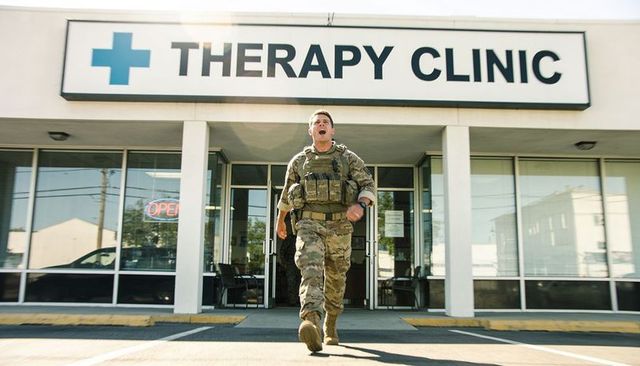 Soldier striding out of therapy clinic wearing tactical vest and shouting