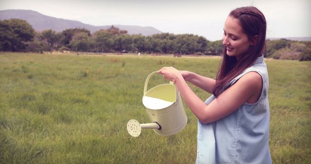 Young Woman Watering Plants in Green Field - Download Free Stock Images Pikwizard.com