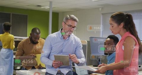 Team Collaborating Around Tablet and Documents in Modern Open Office with Data Overlays