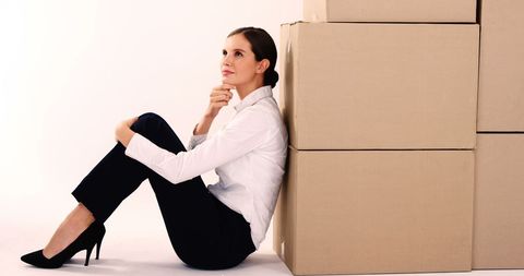 Contemplative Businesswoman Sitting Beside Cardboard Boxes - Download Free Stock Images Pikwizard.com
