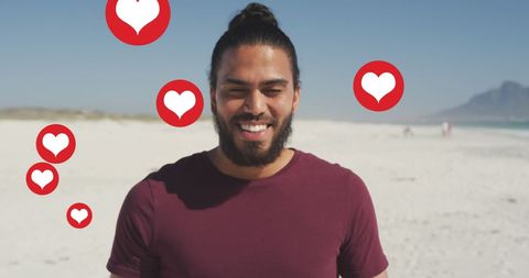 Smiling Man on Beach with Floating Social Media Hearts