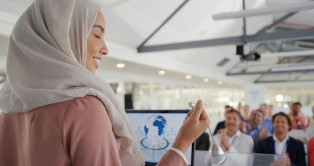 Confident Female Speaker in Hijab Giving Presentation to Diverse Audience - Download Free Stock Images Pikwizard.com