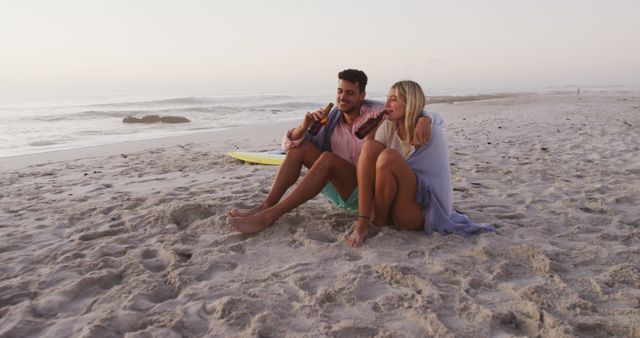 Happy Couple Sitting on Sandy Beach During Sunset Enjoying Drinks - Download Free Stock Images Pikwizard.com