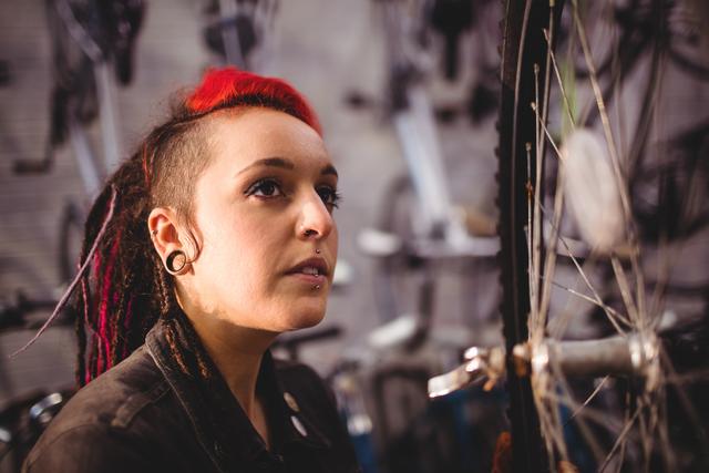 Mechanic with Dreadlocks Inspecting Bicycle Wheel in Workshop - Download Free Stock Images Pikwizard.com