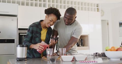 African American Couple Enjoying Juice Prep in Modern Kitchen