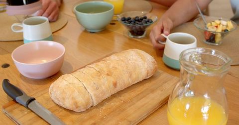 Family Breakfast with Fresh Bread, Orange Juice and Coffee at Comfortable Home