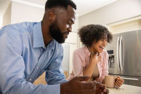 Diverse Couple Laughing Together in Modern Kitchen