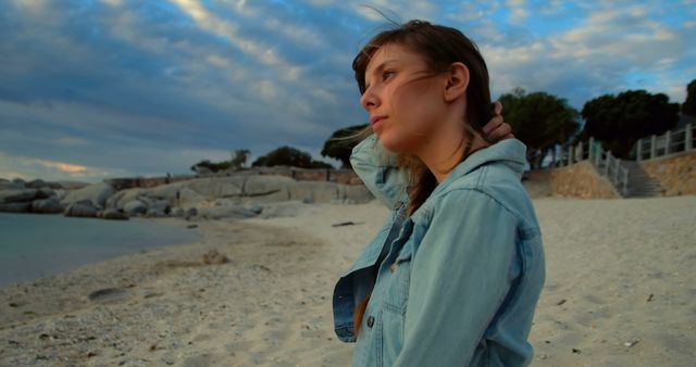 Pensive Woman in Denim Jacket on Sandy Beach at Sunset - Download Free Stock Images Pikwizard.com