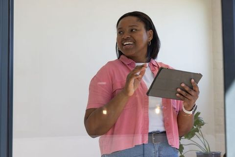 African american woman presenting with tablet in bright modern office environment
