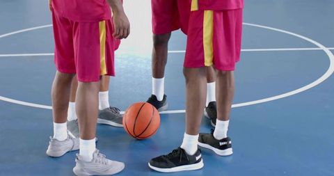 Basketball players huddling on court for strategy discuss
