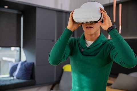 Man adjusting virtual reality headset in modern living room minimalist home vr experience
