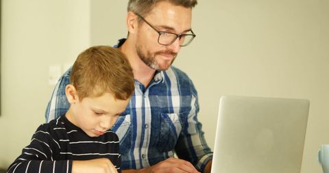 Father and son bonding over educational activity at home