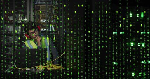 Technician in server room managing data through digital interface