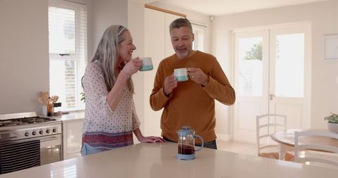 Senior Couple Sharing Morning Coffee in Bright Kitchen