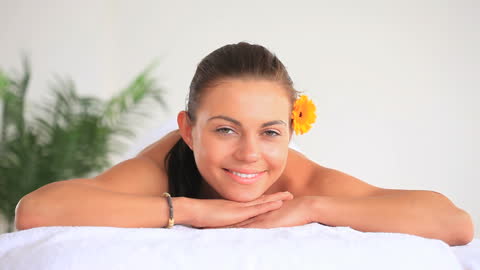 Relaxed Woman Enjoying Spa Day with Flower Accessory